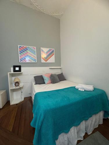 a bedroom with a bed with a blue blanket on it at Hotel Cidade Imperial in Petrópolis