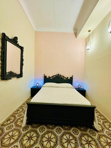a bedroom with a bed and a mirror on the wall at Dimora Barocca in Militello in Val di Catania