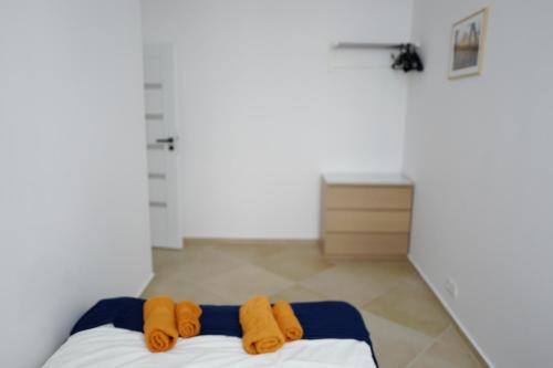 two orange towels on a bed in a room at Apartment In the Heart of Warsaw in Warsaw