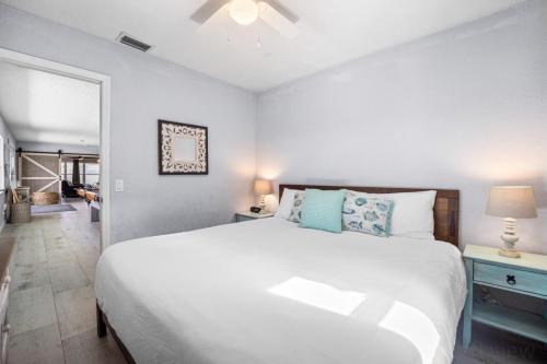 a bedroom with a large white bed with blue pillows at Canal Front Beach Home, Private Pool in Flagler Beach
