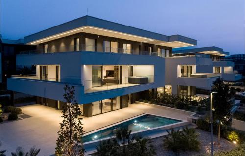 a blue building with a swimming pool in front of it at Lovely Apartment In Malinska With Wifi in Malinska