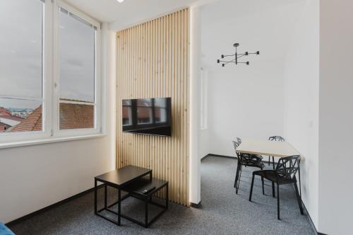 a living room with a table and a tv in a room at Apartmány Prusinovského in Kroměříž