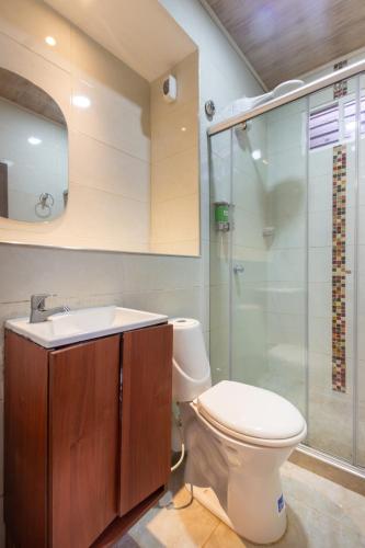 a bathroom with a toilet and a glass shower at MINCA Chunuu - glamping - coworking MINCA in Minca