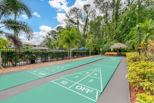 a tennis court in a park with trees at Parkway International Resort in Orlando