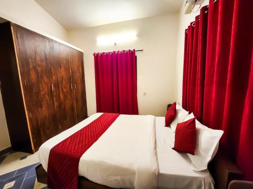 a bedroom with a bed with red curtains at The Plix Villa in Anjuna
