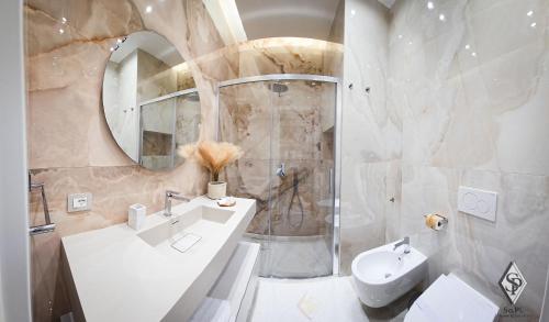 a bathroom with a sink and a toilet and a mirror at SOPI Home in Castellammare di Stabia