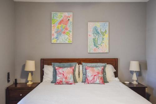 a bedroom with a bed with three pictures on the wall at Palm Bay 305 in Corpus Christi