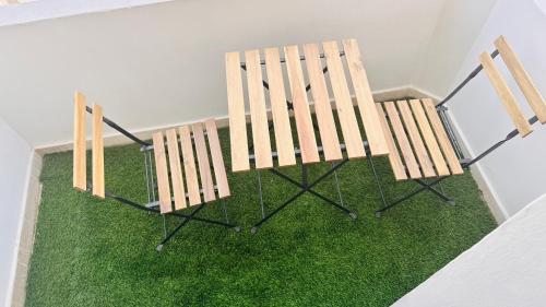 two wooden chairs sitting on a patch of green grass at Capital View in Abu Dhabi