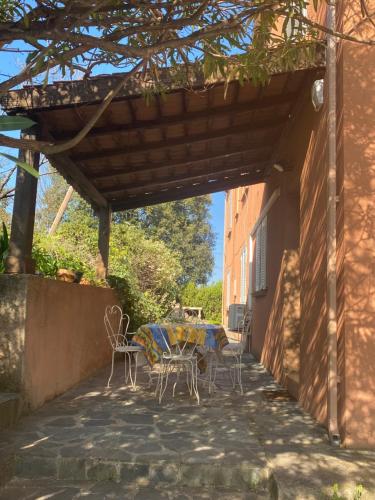 a patio with a table and chairs under a pergola at Appartement T2 Alistro San Giuliano Corse in San-Giuliano