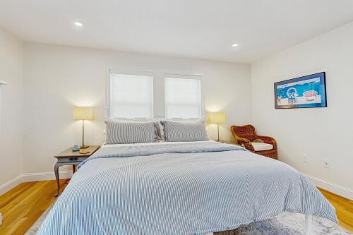 a white bedroom with a large bed and a window at Saggie Beach Hideaway in Sagamore Beach