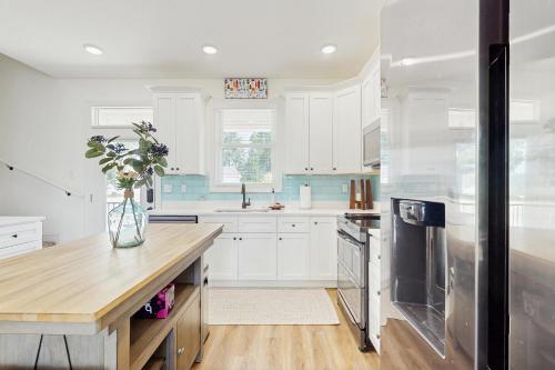 a kitchen with white cabinets and a vase of flowers at Sunshine Shack in La Follette