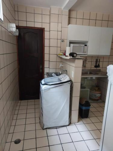 a small kitchen with a sink and a refrigerator at Apartamento em Capim Macio com 03 quatros e cinco camas perto da praia in Natal