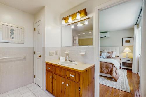 Un baño con lavabo y un dormitorio con cama. en Jack's Dacha, en Dennis