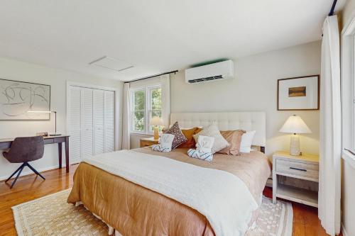 Un dormitorio con una cama grande y un escritorio. en Jack's Dacha, en Dennis