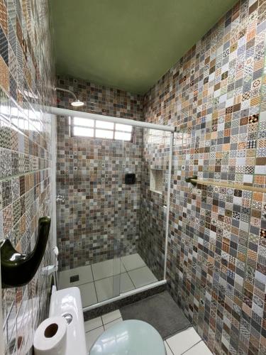 a bathroom with a glass shower with a toilet at Pousada Morango das Palmas in Praia de Palmas