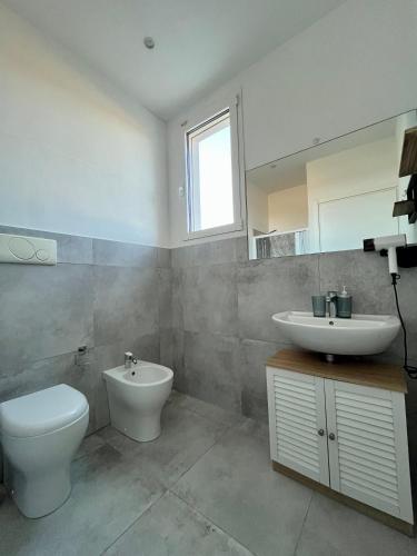 a bathroom with a toilet and a sink at Arneo Rooms in Torre Lapillo