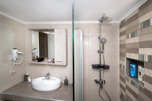 un baño con lavabo y ducha en Kaponia's Houses, en Aegina Town