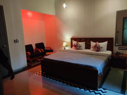 a bedroom with a bed and two chairs in it at awesome family homestay in Agra