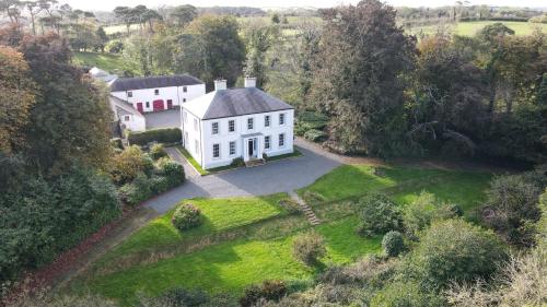 an aerial view of a large white house in a field at Ashville Georgian House in Killinchy