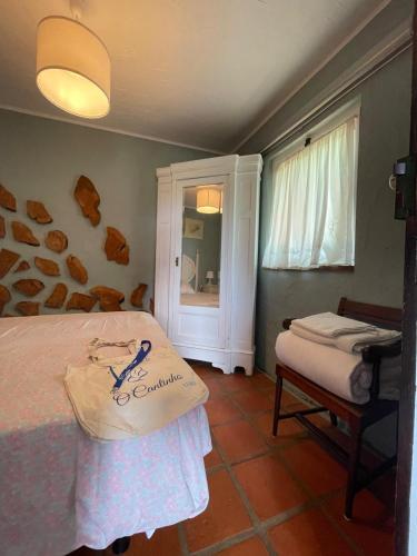 a bedroom with a bed and a window and a chair at O Cantinho Alojamento Local in Luso