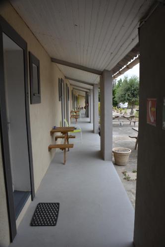 a hallway of a building with a table and benches at Hotel Motel Limoux in Limoux