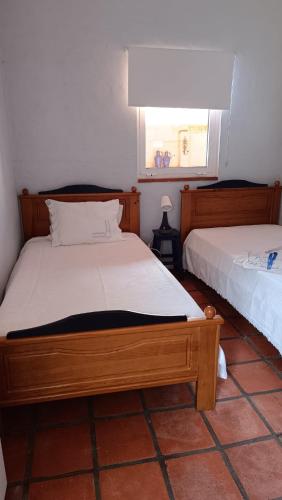 a bedroom with two beds and a window at O Cantinho Alojamento Local in Luso