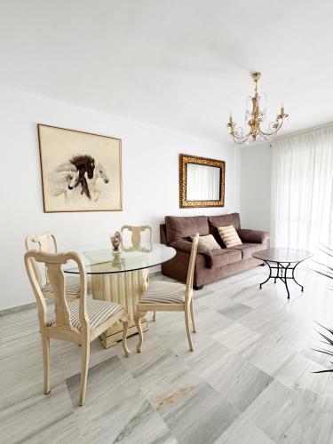 a living room with a table and a couch at Apartamento comedia in Sanlúcar de Barrameda