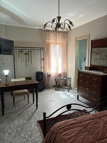 Una habitación con un dormitorio con un escritorio y una cómoda. en Borgo Riolo, en Cosenza