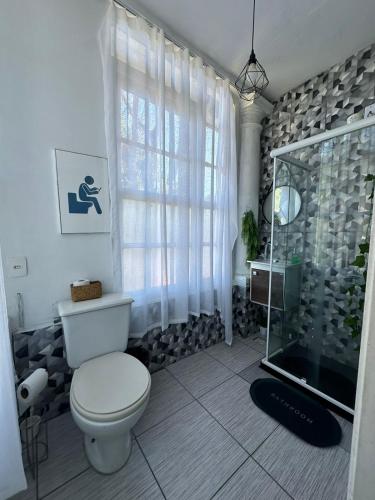 a bathroom with a toilet and a glass shower at Hotel Cidade Imperial in Petrópolis