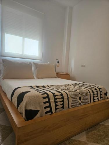 a bed with a wooden frame in a bedroom at Rincón del Guadiana in Ayamonte