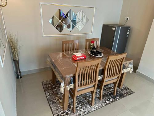 a dining room table with four chairs and a refrigerator at NK Homes - Full Furnished Serviced Apartments in Hyderabad