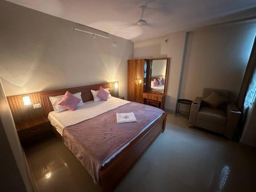 a bedroom with a bed with a mirror and a chair at NK Homes - Full Furnished Serviced Apartments in Hyderabad