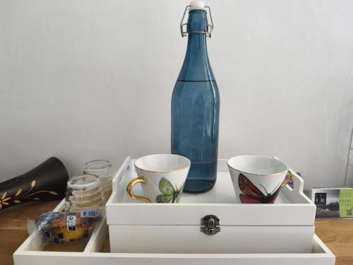 a white drawer with two cups and a blue bottle at VILLA DE SOUZA in Bouillé-Loretz