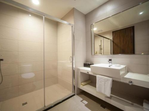 a bathroom with a shower and a sink and a mirror at Lealea Garden Hotels - Sun Lake in Yuchi