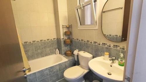 a bathroom with a toilet and a sink and a mirror at Ferienwohnung mit Meerblick in Khlorakas