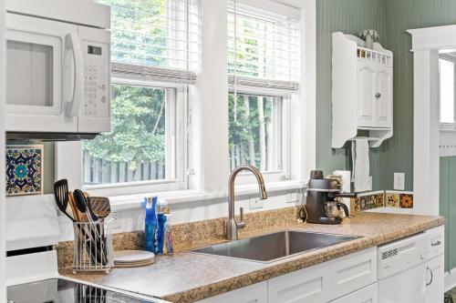 cocina blanca con fregadero y 2 ventanas en Happy Place- Midtown, Pet-Friendly, close to beach, en Wilmington