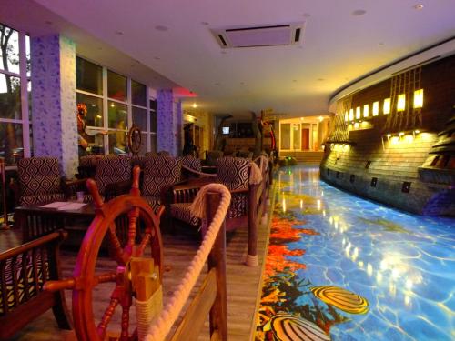 a restaurant with a swimming pool in the middle of a room at Pirates Resort in Mamaia