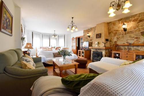 ein Wohnzimmer mit Sofas und einer Steinmauer in der Unterkunft Los Rosales de Venturada in Venturada