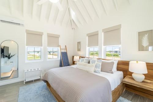 サン・ペドロにあるCanalfront Retreat and Pool Club at Mahogany Bayの白いベッドルーム(大型ベッド1台、窓付)