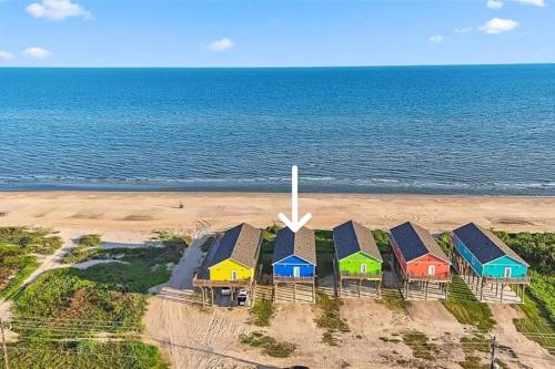 a row of colorful houses on the beach at Beachfront Views with 3 bedrooms and 2 bathrooms in Bolivar Peninsula