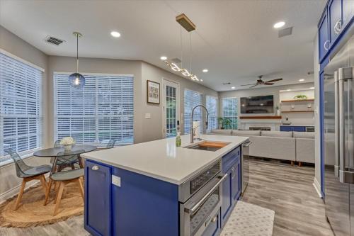 a large kitchen with blue cabinets and a table at The Woodlands Gem with Pool and Spa in The Woodlands