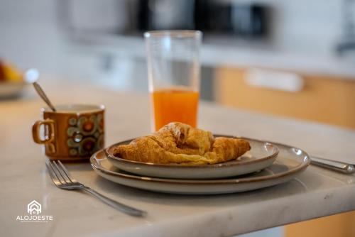 a plate of food and a glass of orange juice at Seaside Santa Cruz- Beachfront Apt 3 BDR with BBQ in Silveira