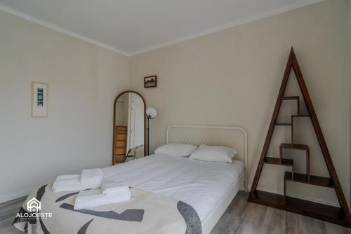 a bedroom with a white bed and a ladder at Seaside Santa Cruz- Beachfront Apt 3 BDR with BBQ in Silveira