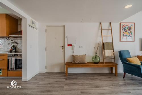 a living room with a table and a blue chair at Seaside Santa Cruz- Beachfront Apt 3 BDR with BBQ in Silveira
