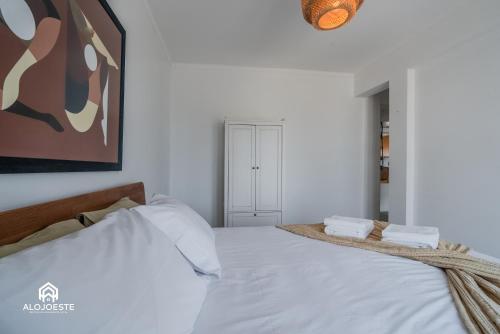 a bedroom with a large white bed with two pillows at Seaside Santa Cruz- Beachfront Apt 3 BDR with BBQ in Silveira