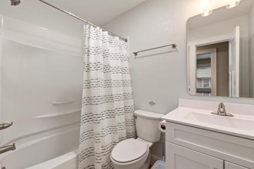 a white bathroom with a toilet and a sink at Wright On Time in Kill Devil Hills