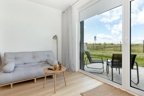 a living room with a couch and a table at Dorsza Green View Pogórze by Solarento in Pogórze