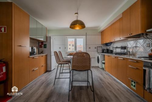 a kitchen with wooden cabinets and a table with chairs at Seaside Santa Cruz- Beachfront Apt 3 BDR with BBQ in Silveira