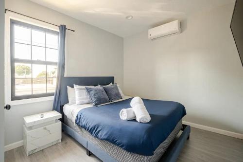 a bedroom with a blue bed and a window at Modern 3-Bdrm Apt in Black Rock in Bridgeport
