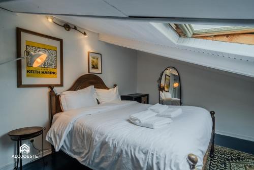a bedroom with a large bed with white sheets at Seaside Santa Cruz- Beachfront Apt 3 BDR with BBQ in Silveira